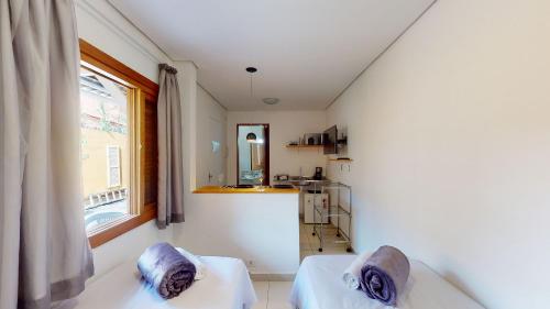 Zimmer mit 2 Betten und einer Küche mit Fenster in der Unterkunft Studio 6 Pinheiros by Oba in São Paulo