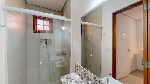 ein Bad mit einer Glasdusche und einem Waschbecken in der Unterkunft Studio 6 Pinheiros by Oba in São Paulo