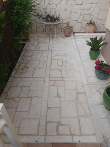 a patio with a table and potted plants at Apartments Emma in Biograd na Moru