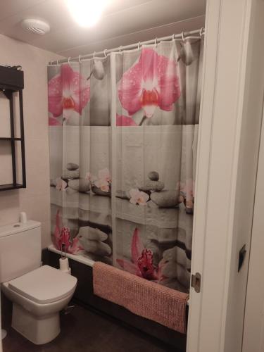 a bathroom with a toilet and a shower curtain with pink flowers at WANDA Patrimonio parking gratis LICENCIA TURISTICA VT-13975 in Alcalá de Henares