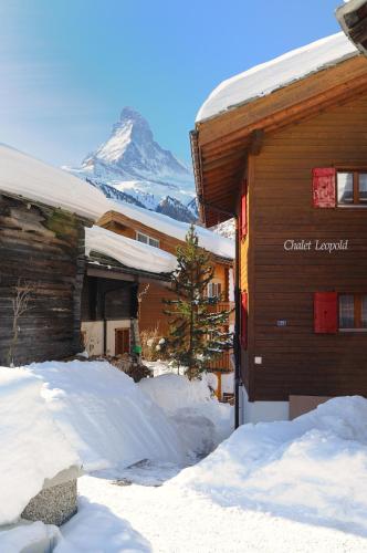 a snow covered building with a mountain in the background at Haus Leopold in Zermatt