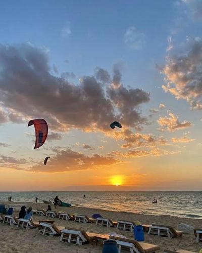 a group of people on the beach flying kites at La Hacienda Ras Sudr Two Bedroom Chalet Ras Matarma in Ras Sedr
