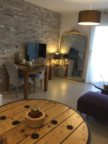 sala de estar con mesa y espejo en Mini-villa mitoyenne de type F2 proche Golfe de Lava en Appietto