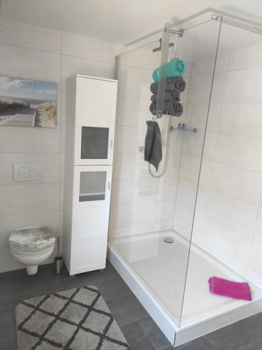 a white bathroom with a shower and a toilet at Ferienwohnung Detlev 