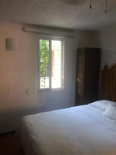 1 dormitorio con cama blanca y ventana en Casablanca, en Cancún