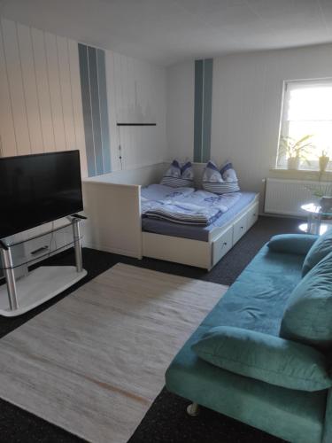a bedroom with a bed and a flat screen tv at Ferienwohnung Detlev 