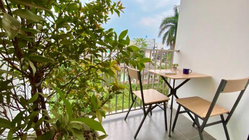 een balkon met een tafel, stoelen en planten bij Cozy place @ Chiangrai in Chiang Rai