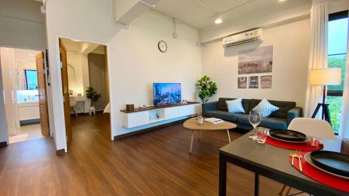 Cozy place @ Chiangrai في شيانج راي: غرفة معيشة مع أريكة وطاولة