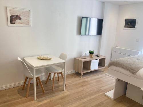 1 dormitorio con mesa, sillas y 1 cama en CP luxury studio en Gibraltar