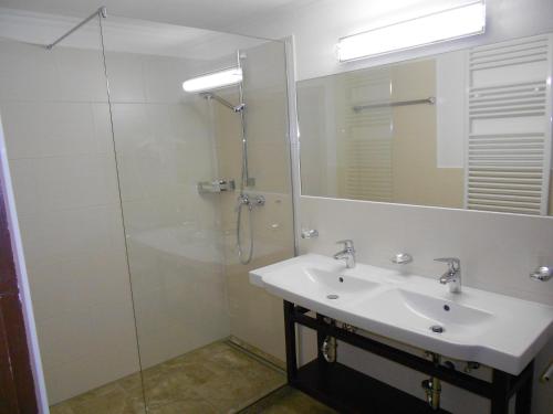 a bathroom with a sink and a glass shower at Gästehaus Weißes Rössl in Reit im Winkl