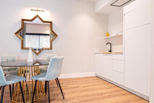 a dining room with a table and chairs and a mirror at Genteel Home Betis 67 in Seville