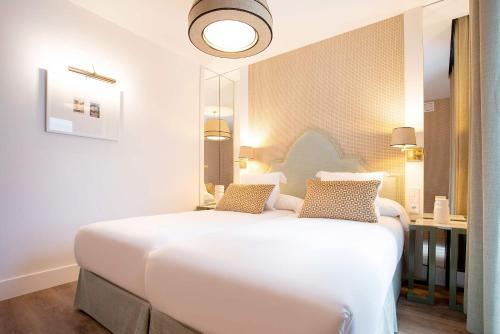 a bedroom with a large white bed and a desk at Genteel Home Betis 67 in Seville