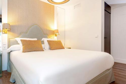 a bedroom with a large white bed with two pillows at Genteel Home Betis 67 in Seville