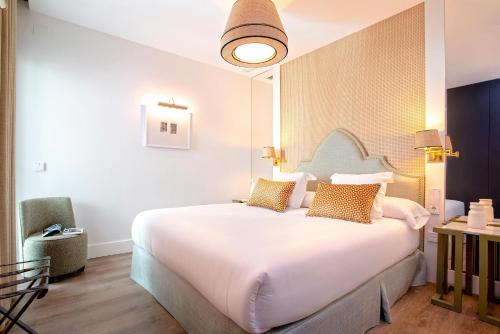 a bedroom with a large white bed with pillows at Genteel Home Betis 67 in Seville