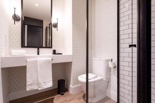 a bathroom with a toilet and a sink and a mirror at Genteel Home Betis 67 in Seville