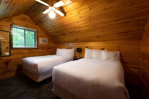 a bedroom with two beds in a wooden cabin at Depe Dene Lakeside Resort in Lake George