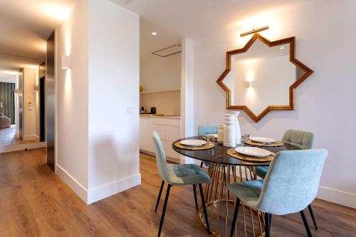 a dining room with a table and chairs and a mirror at Genteel Home Betis 67 in Seville