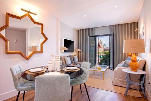 a living room with a table and chairs and a couch at Genteel Home Betis 67 in Seville