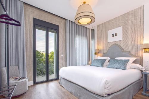 a bedroom with a large bed and a large window at Genteel Home Betis 67 in Seville