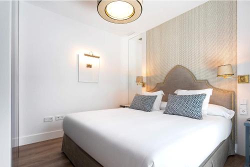 a bedroom with a large white bed with two pillows at Genteel Home Betis 67 in Seville