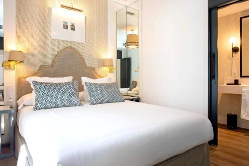 a bedroom with a large white bed with blue pillows at Genteel Home Betis 67 in Seville