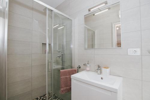 カシュテラにあるRoyal Blue House 1の洗面台とシャワー付きの白いバスルーム