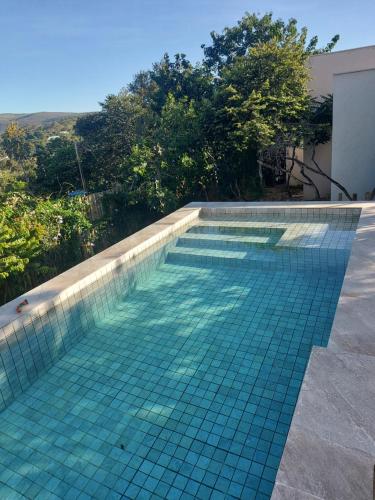 una piscina con suelo de baldosa turquesa en Statera Host, en Alto Paraíso de Goiás
