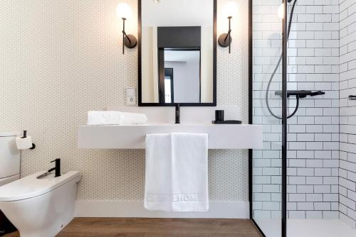 a bathroom with a sink and a toilet and a mirror at Genteel Home Betis 67 in Seville