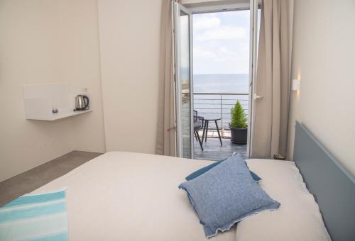 a bedroom with a bed with a view of the ocean at La casa del pescatore in Cala Gonone