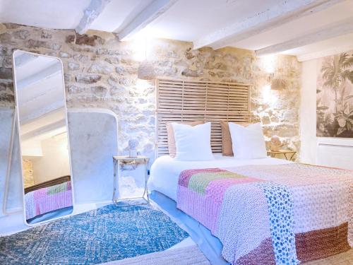 サン・ローラン・デ・ザルブルにあるRésidence du Plataneの石壁のベッドルーム1室(ベッド1台付)