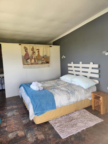 ein Schlafzimmer mit einem Bett und einem Wandgemälde in der Unterkunft Mulberry Country Cottage in Brits