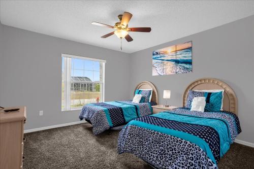 a bedroom with two beds and a ceiling fan at Amazing 4 Bedrooms 3 Bath with private pool, near Disney and Universal! in Davenport