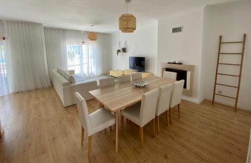 a living room with a wooden table and chairs at Alice's House in Nazaré