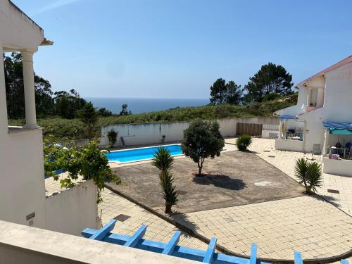 a villa with a swimming pool and blue chairs at Alice's House in Nazaré