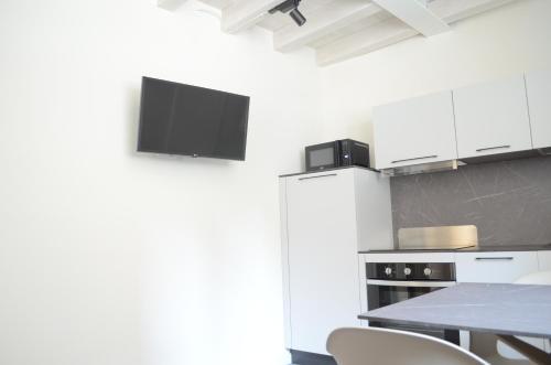 a kitchen with a refrigerator and a table with chairs at La Casa Incartata in Toscolano Maderno