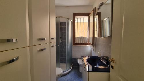 a bathroom with a sink and a toilet and a window at Appartamento Blu Relax in Capoliveri