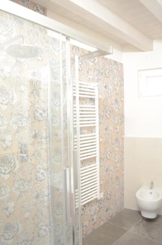 a bathroom with a shower with a toilet and a sink at La Casa Incartata in Toscolano Maderno