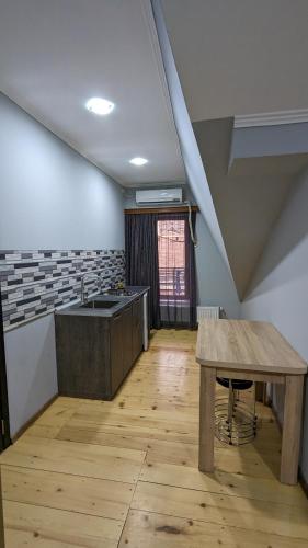 a kitchen with a wooden table and a sink at Shera in Borjomi