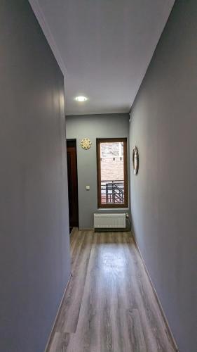 an empty living room with a window and wooden floors at Shera in Borjomi