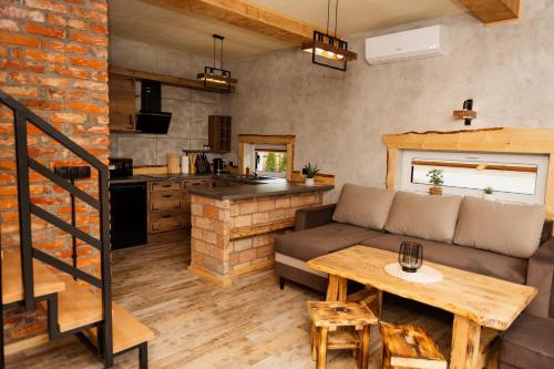 a living room and kitchen with a couch and a table at Bez Zegarka Osada nad Jeziorem Rospuda in Filipów