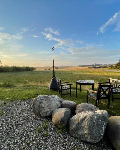 a park with two benches and a table and some rocks at Room 7 - Hawkraft kulturhotel in Vestervig