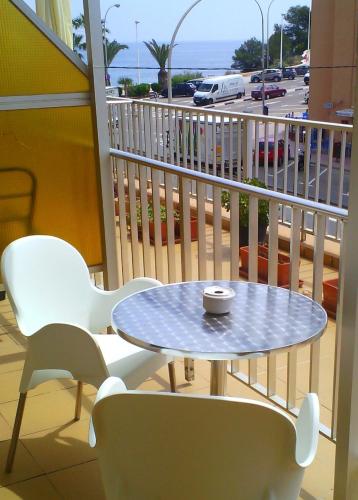 a table and chairs on a balcony with a view of a street at Pensión El Hidalgo in Calpe
