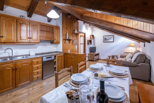 a kitchen and living room with a table and a couch at Apartamentos Casa Pichuana in Benasque