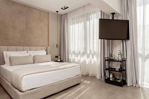 Un dormitorio con una cama y una ventana grande. en La Maison Suites, en Zakynthos
