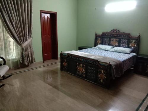a bedroom with a bed and a red door at Amira Villa 1 Kanal 5 bedroom house, Johar Town Lahore in Lahore