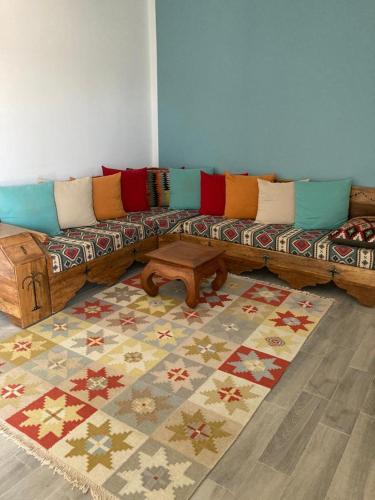 ein Wohnzimmer mit einem Sofa und einem Tisch in der Unterkunft Appartement Djerba in El Mây