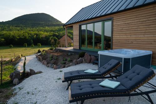 two lounge chairs and a tub in front of a house at Istvándy Birtok in Káptalantóti