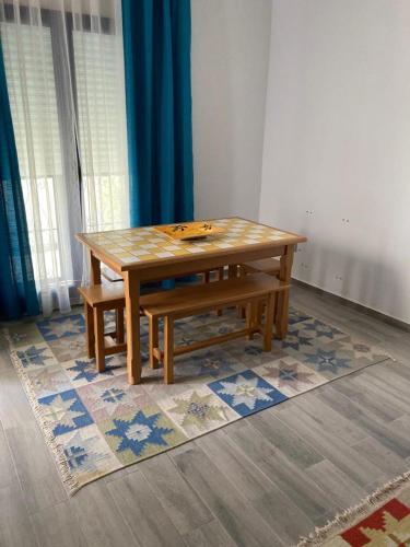 einem Holztisch und einer auf einem Teppich sitzenden Bank in der Unterkunft Appartement Djerba in El Mây