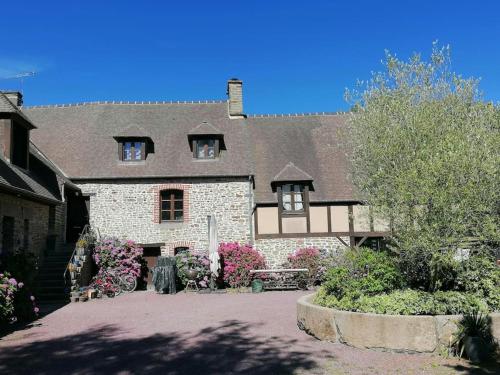 a house with a building with flowers in front of it at Sunset Family Guesthouse Mont Saint Michel in Céaux