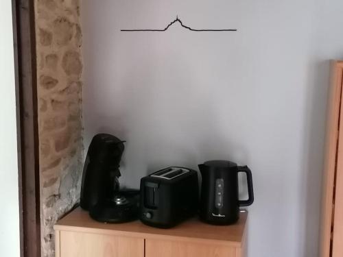 a coffee maker and a toaster sitting on a cabinet at Sunset Family Guesthouse Mont Saint Michel in Céaux